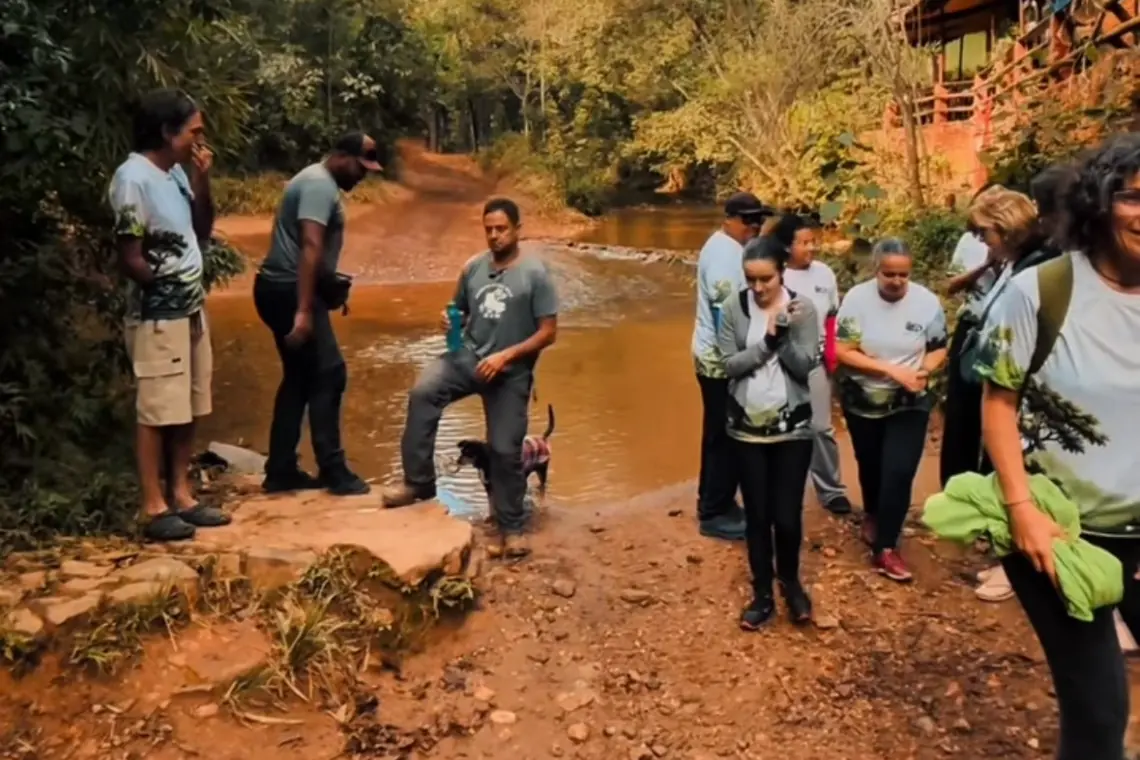 Caminhantes atravessando um córrego na trilha